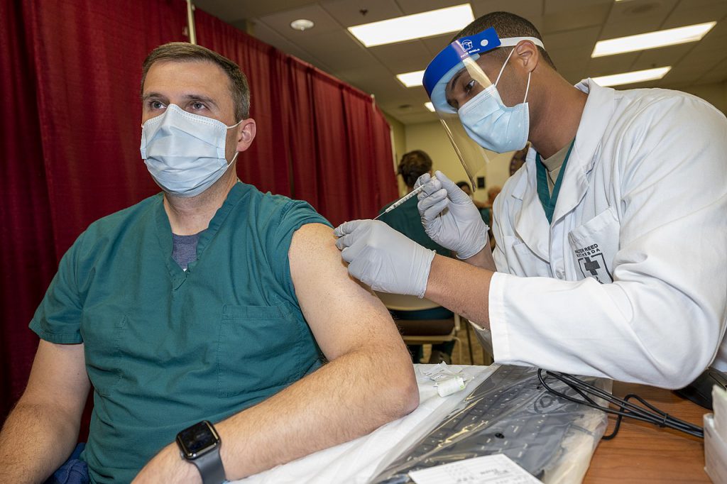Army Col. Sean Dooley receives a Covid-19 vaccination at Walter Reed National Military Medical Center, Bethesda