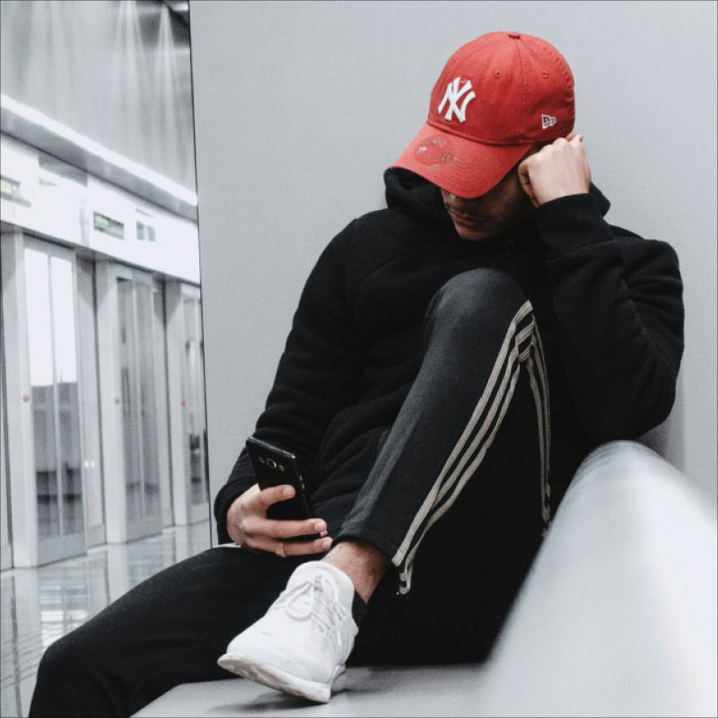 Young man in sportswear scrolling on his mobile phone
